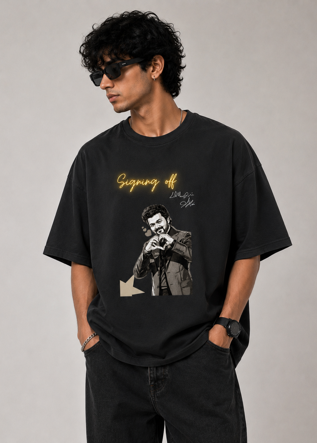 Male model wearing a black oversized graphic t-shirt featuring the "Signing Off" design with glowing handwritten typography and monochrome artwork. Premium unisex streetwear t-shirt by LowKey.
