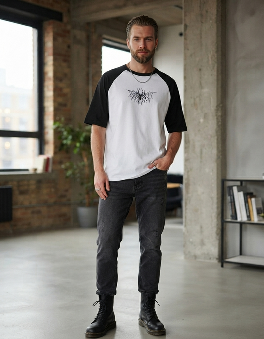 Model wearing black and white oversized raglan t-shirt with spider web graphic print on chest, front view