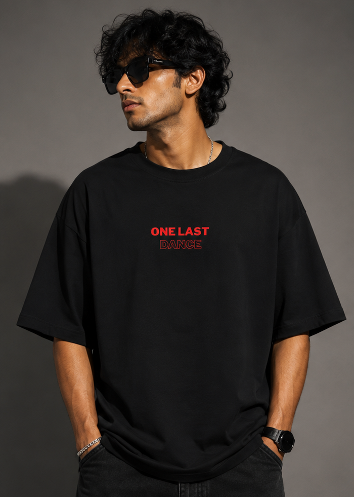 Model wearing black oversized t-shirt with small One Last Dance typography print on chest