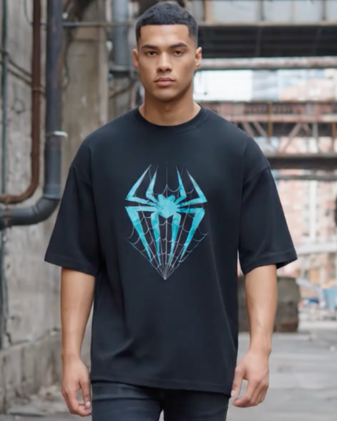 Front view of a black oversized t-shirt worn by a model from Lowkey fashion featuring a teal spider and web graphic in the center.