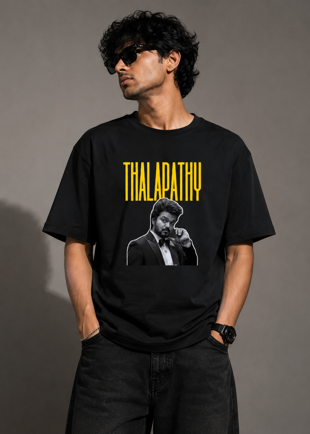 Model wearing black t-shirt with Thalapathy typography and black and white portrait print, front view
