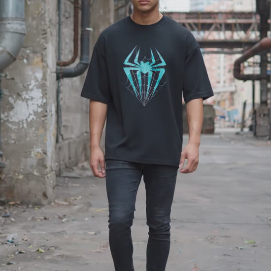 Model wearing a oversized t-shirt from Lowkey fashion featuring a teal spider and web graphic in the center.