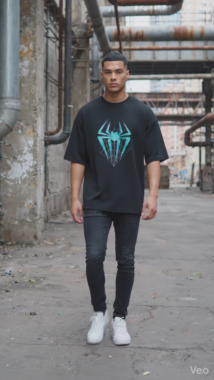 Model wearing a oversized t-shirt from Lowkey fashion featuring a teal spider and web graphic in the center.