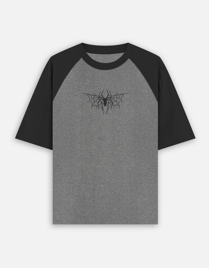 Black and charcoal oversized raglan t-shirt with spider web graphic print on chest, front view