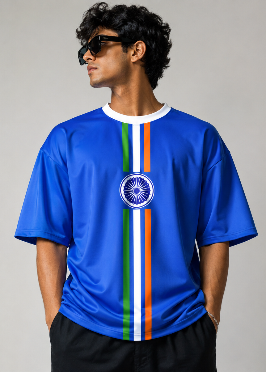 A man wearing a royal blue short-sleeve t-shirt with a vertical Indian flag stripe design down the center and the Indian national emblem on the chest, posed against a neutral gray background.