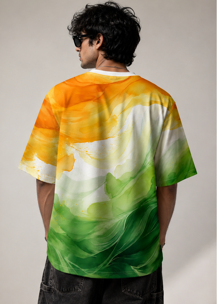 A man modeling a short-sleeve crewneck t-shirt with a colorful abstract print in orange, yellow, white, and green. The image features two views: a front view on the left and a back view on the right, set against a plain light gray studio background.