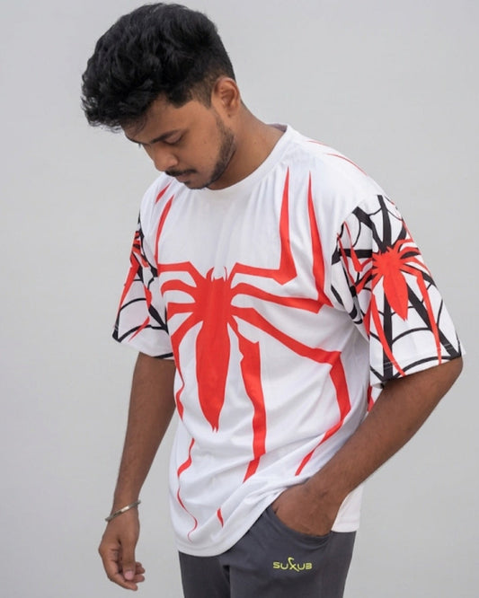 A man wearing a white oversized t-shirt with a large red spider logo on the chest and black web patterns on the sleeves.